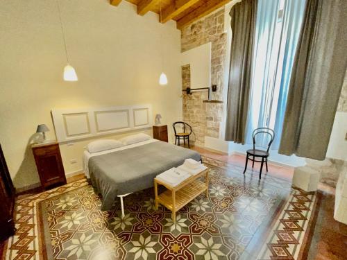 een slaapkamer met een bed en een tafel en stoelen bij Palazzo Lupicini Affittacamere in Bisceglie