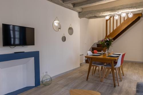 a living room with a table and a tv at Chez Gaspéli in Saumur