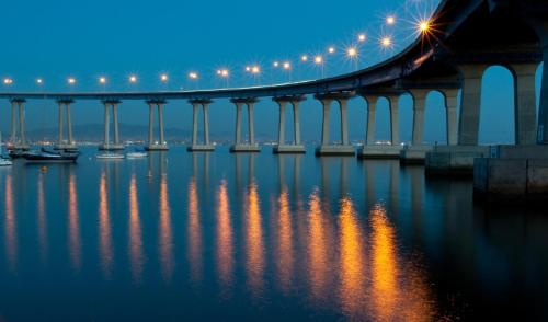 
a bridge over a body of water with a train on it at Hotel Marisol Coronado in San Diego

