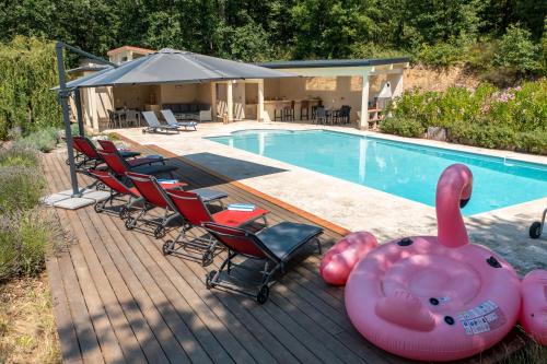 a swimming pool with chairs and an inflatable elephant next to it at Les Cazettes in Damiatte
