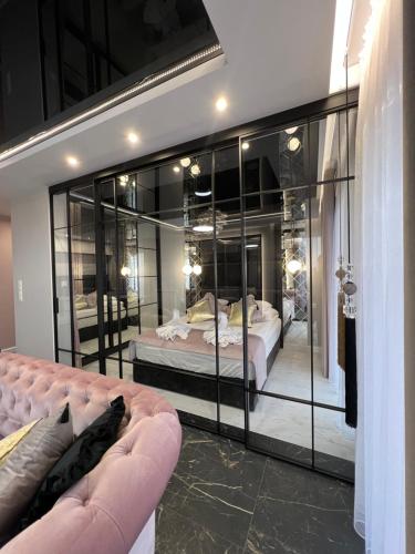 Zimmer mit einem Bett und einer Glaswand in der Unterkunft Apartament Primavera 2 z Sauną i Jacuzzi in Kielce