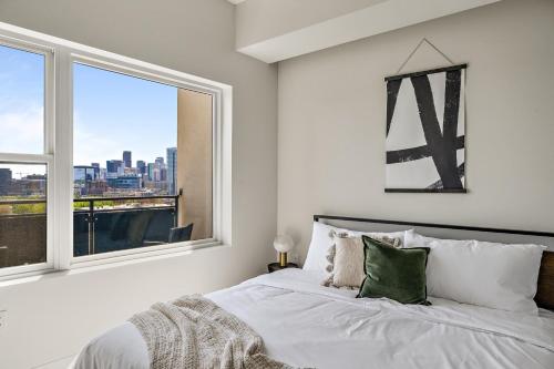 a bedroom with a white bed with a window at A Denver Skyline State of Mind - Zuni Lofts in Denver