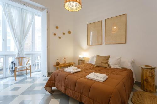 sypialnia z łóżkiem i dużym oknem w obiekcie The QUEEN's Designer Apartment by Cadiz4Rentals w Kadyksie