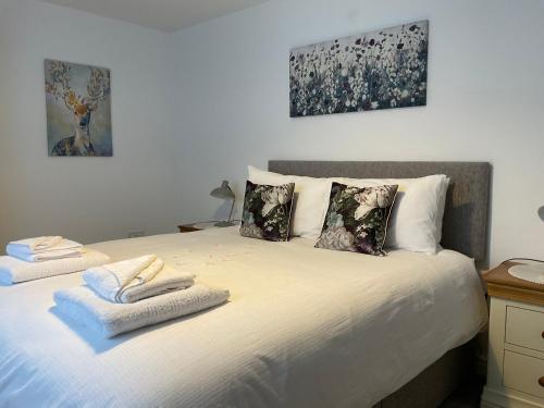 1 dormitorio con 1 cama con toallas en Anvil Cottage, en Mold