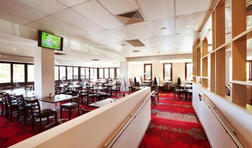 a dining room with tables and chairs and a flat screen tv at Nightcap at Springwood Hotel in Springwood