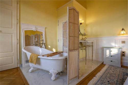 a bathroom with a large tub and yellow walls at Les Cazettes in Damiatte