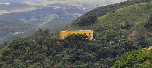 un edificio amarillo en el lateral de una montaña en Hotel Du Rastro, en Lauro Müller