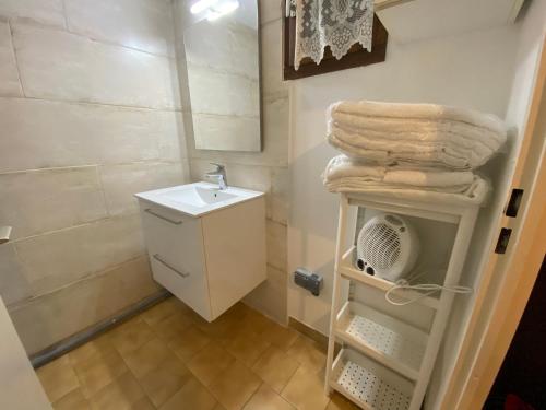 un bagno con lavandino e asciugamani su una mensola di Superbe Duplex aux Saintes terrasse plein sud 3*** a Saintes-Maries-de-la-Mer