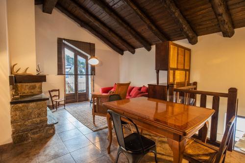 ein Wohnzimmer mit einem Holztisch und einem Sofa in der Unterkunft JAT MOUNTAIN HOUSES - Casa Jarca 2on pis Àtic, a 1km de Canillo in Prats