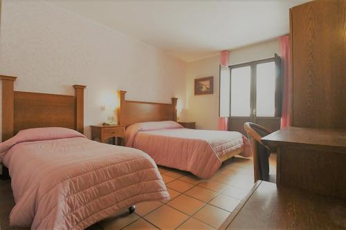 um quarto de hotel com duas camas e uma janela em Hotel Cristal em Roccaraso