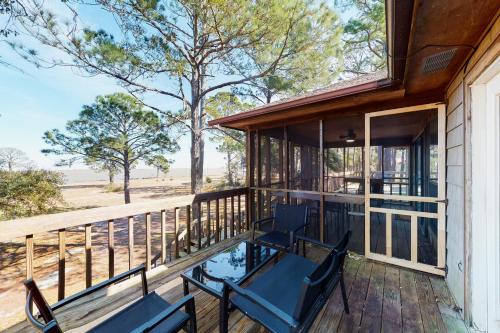two chairs on a porch with a view of the beach at Coronado Cove Cottage in Dauphin Island