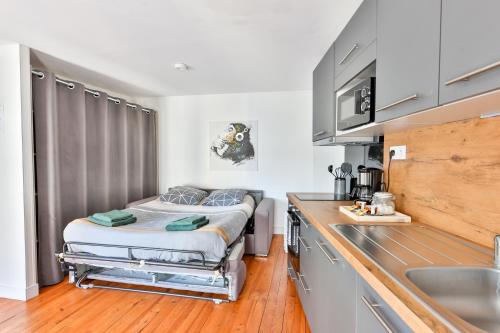 a kitchen with a bed in the middle of a room at LE DOUILLET #Centre ville #100m des quais in Cognac