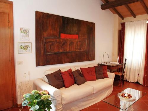 una sala de estar con un sofá blanco con almohadas rojas en Belvilla by OYO Elegant flat in historic villa, en Montepulciano