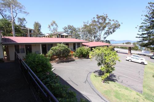 a building with a car parked in a parking lot at Waterview Gosford Motor Inn in Gosford