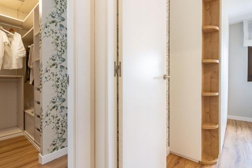 a walk in closet with white walls and wooden shelves at AH El Rincón del Condado VUT2805AS in Noreña