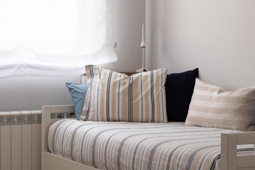 a bed with striped pillows in a room with a window at AH El Rincón del Condado VUT2805AS in Noreña