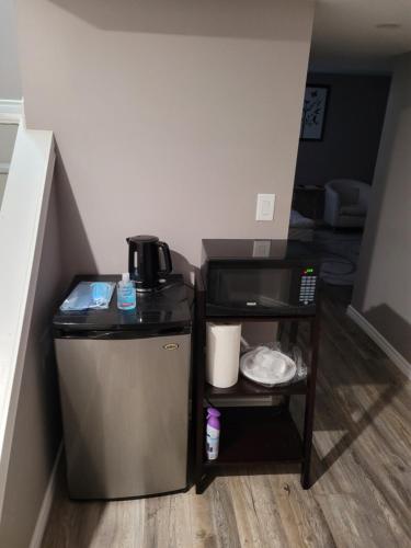 a small refrigerator in a room with a table at Adorable Studio Basement Suite in South Barrie in Barrie