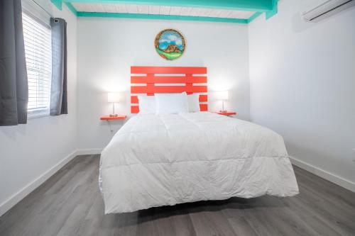 a white bedroom with a large bed with two lamps at Salt Air Inn & Suites in Atlantic Beach