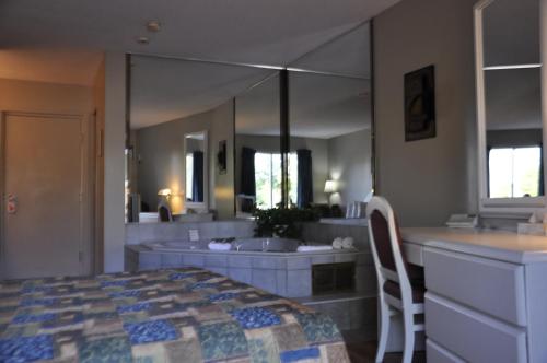 a bathroom with a bed and a large mirror at Motel les Pignons Verts in Gatineau