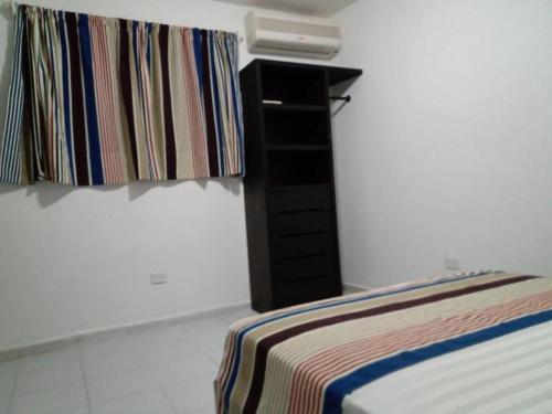 a bedroom with a bed and a dresser in it at Las Palmas HOSTAL Cancun in Cancún