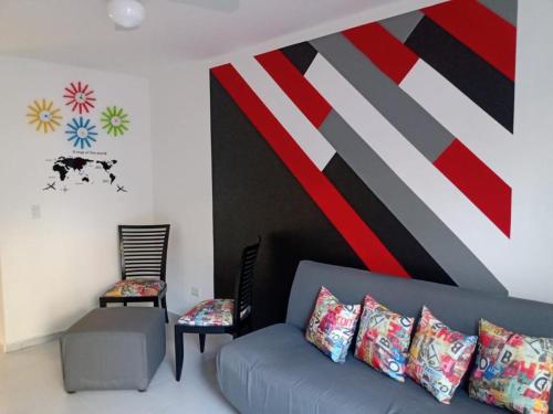 a living room with a couch and a large painting on the wall at Las Palmas HOSTAL Cancun in Cancún