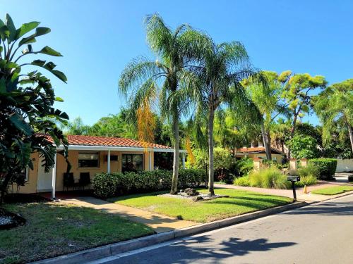 a house with palm trees in front of a street at Tropical Villas Of Venice Beach in Venice