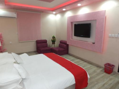 a hotel room with a bed and a tv at فندق ادوماتو ADOMATo HOTEl in Dawmat al Jandal