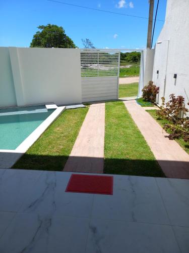 a backyard with a pool and a fence at VIA CARNEIROS DUPLEX in Praia dos Carneiros