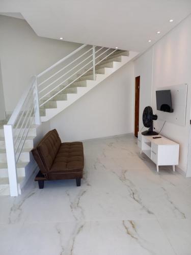 a living room with a chair and a staircase at VIA CARNEIROS DUPLEX in Praia dos Carneiros