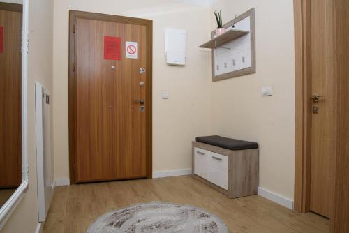 a hallway with a door and a stool and a rug at Apartman Jaman - Novi Pazar in Novi Pazar