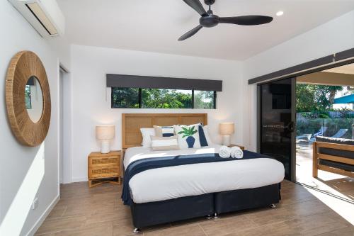 - une chambre avec un lit et un ventilateur de plafond dans l'établissement Paradiso, à Port Douglas