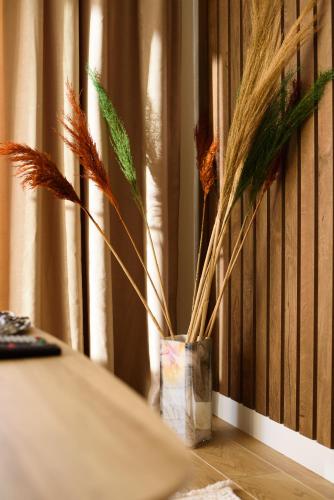 a vase with some plants in it on a table at Apartman Jaman - Novi Pazar in Novi Pazar