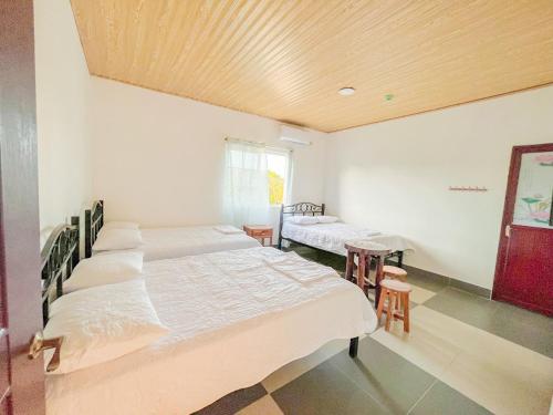 a room with four beds and a wooden ceiling at Hospedaje Las Uvas in Las Uvas