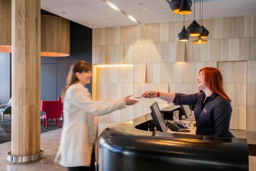 two women standing in front of a counter at ibis Adelaide in Adelaide