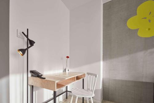 a desk in a room with a chair and a table at Flowers Hotel Essen in Essen