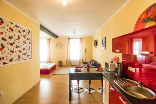 a kitchen with a sink and a living room at Tribunei Apartment Sibiu in Sibiu