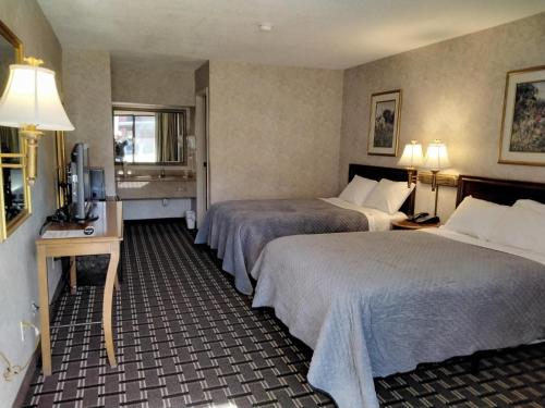 um quarto de hotel com duas camas e uma televisão em Onley Inn em Onley