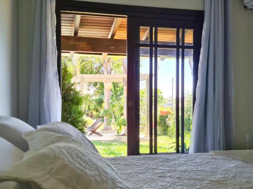 a bedroom with a bed and a sliding glass door at Pousada Brisas do Rio in Torres