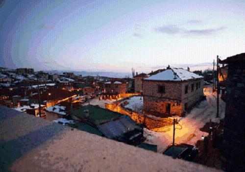 a view of a city with snow on the roofs at Gioras Hotel in Palaios Agios Athanasios