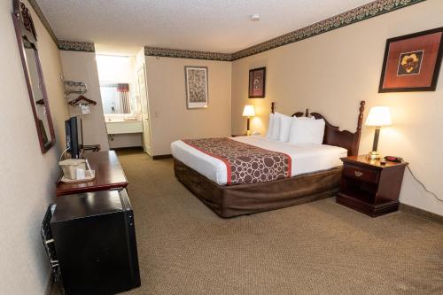 a hotel room with a bed and a television at Hilltop Inn & Suites, near Foxwoods Casino in North Stonington