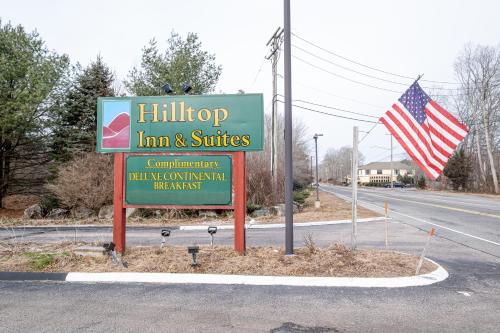 a sign for a inn and suites with an american flag at Hilltop Inn & Suites, near Foxwoods Casino in North Stonington