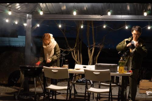 a man and a woman standing at a table in a tent at SWEET VILLA TAKASAMA in Fujiyoshida