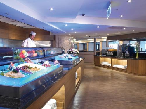 a chef standing behind a counter in a restaurant at City Suites - Taoyuan Gateway in Dayuan