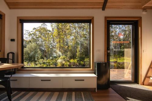 a large window in a room with a table and chairs at Tiny Escapes Cradle Valley in Moina