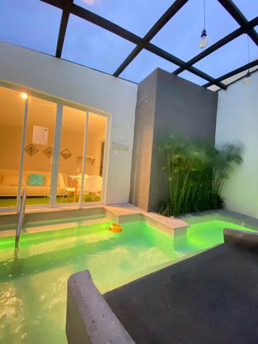 a swimming pool in a house with green water at Springhills Quito Airport in Tababela
