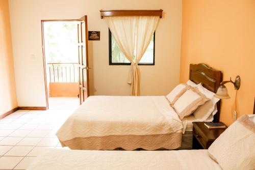 a hotel room with two beds and a window at Hotel El Arco in San Martín Zapotitlán