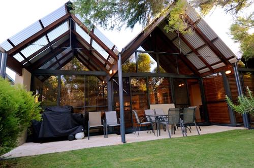 a pavilion with a table and chairs in a yard at Whalers Cove Villas in Dunsborough