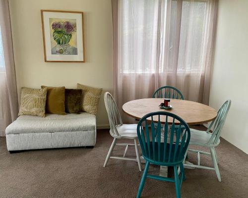 sala de estar con mesa, sillas y sofá en The Source, Otways en Tanybryn