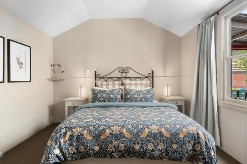a bedroom with a bed with a blue comforter at Cromwell Cutie - Cromwell Holiday Home in Cromwell