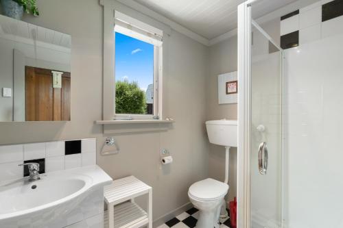 a white bathroom with a sink and a toilet at Cromwell Cutie - Cromwell Holiday Home in Cromwell